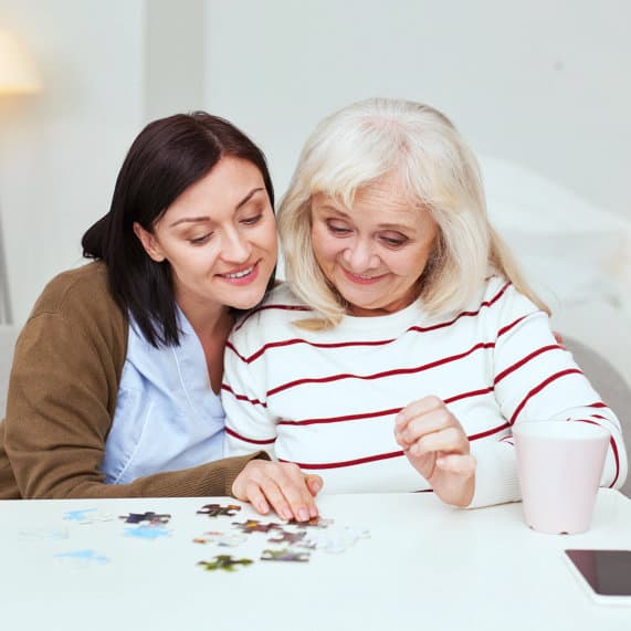 caregiver and elder patient solving puzzle